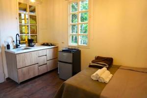 cocina con cama y lavabo en una habitación en ENCANTO Minicasitas en medio de la naturaleza, en Santa Elena