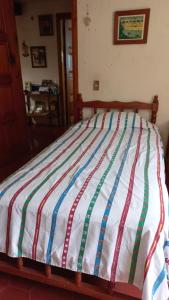 a bed with a striped comforter in a bedroom at Casa Nina in San Cristóbal de Las Casas