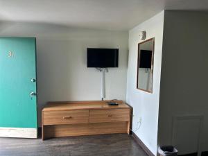 Hillcrist Motel في Aurora: غرفة مزينة وتلفزيون على الحائط