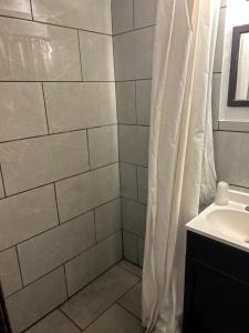 Hillcrist Motel في Aurora: حمام مع دش ومغسلة