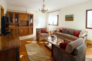 a living room with a couch and a table at Gaia cottage with garden in Epanomi