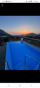 a picture of a blue pool with the sunset in the background at Kareshome-Privacy-view in Kalymnos