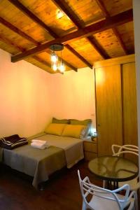 1 dormitorio con 1 cama, mesa y sillas en ENCANTO Minicasitas en medio de la naturaleza en Santa Elena