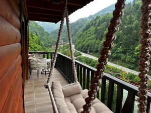 a swing on a balcony with a view of a mountain at HiraBungalov in Çamlıhemşin