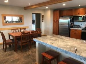 a kitchen and dining room with a table and a refrigerator at Morning Star Vista near Yosemite - countryside with mountain views in Mariposa