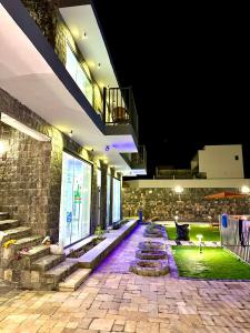 a building with a stone walkway at night at JA view chalet in Duwaykhīlah