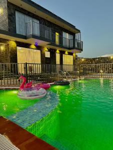 a swimming pool with two rubber ducks in the water at JA view chalet in Duwaykhīlah