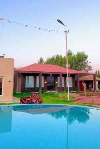 a house with a swimming pool in front of a house at Golden Sands Resort in Qibāʼ