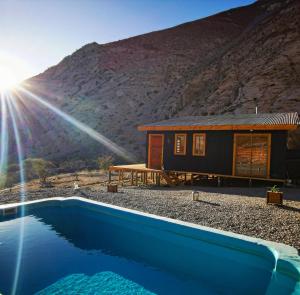 a house with a swimming pool in front of a mountain at Refugio Alma de Montaña, piscina privada in Monte Grande