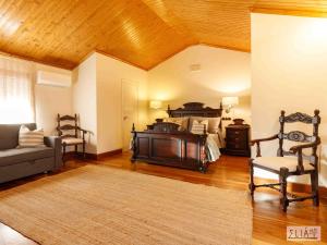 a bedroom with a bed and a couch and a chair at Villa Eliá in Arcas