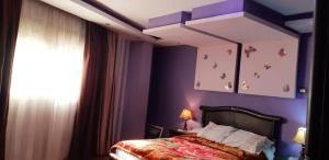 カイロにある٣٥ شارع المشتل تقسيم الشيشيني كورنيش المعادي مستشفىالسلام الدولي والنيل بدراوي وجنينのベッドルーム1室(紫の壁のベッド1台、窓付)