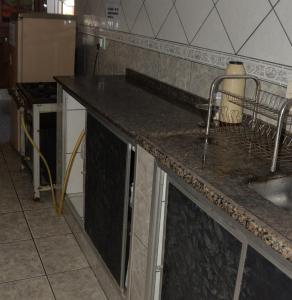 a kitchen with a sink and a counter top at Oro Hospedaria in Ouro Preto