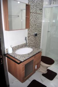 a bathroom with a sink and a shower and a toilet at Apto Meia Praia in Itapema