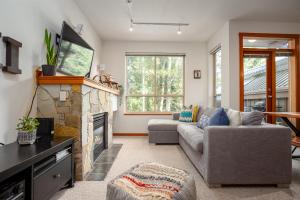 a living room with a couch and a fireplace at Bright Multi-Level Home in Whistler