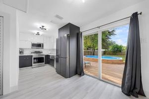 una cocina con una puerta corredera de cristal que conduce a una piscina en Home In Fort Lauderdale 3 Bedrooms & private pool!, en Fort Lauderdale