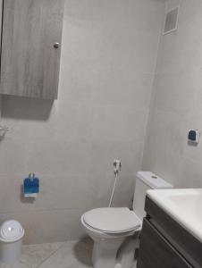 Baño blanco con aseo y lavamanos en Appartement Cozy Louizia en Ben Yakhlef