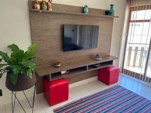 a living room with a television on a wooden wall at Lindo apartamento no centro de Águas de Lindóia in Águas de Lindóia