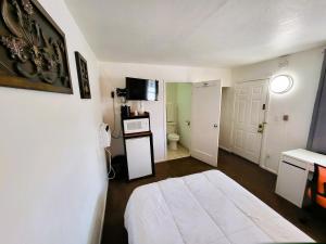 a small room with a bed and a bathroom at Rose's Motel in Willcox