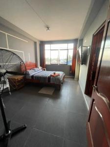 een slaapkamer met een bed en een groot raam bij HOSPEDAJE SCOMIL in Pucallpa