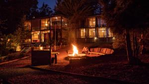 un foyer extérieur en face d'une maison la nuit dans l'établissement Surf Lodge Punta de Lobos, à Pichilemu