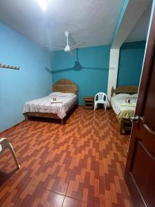 een slaapkamer met 2 bedden en een houten vloer bij HOSPEDAJE SCOMIL in Pucallpa
