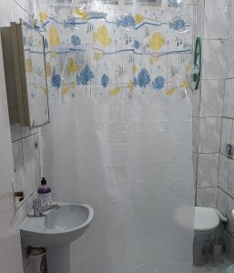 a bathroom with a sink and a shower curtain at Kitnet Ubatuba in Ubatuba