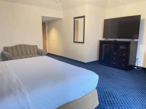 a hotel room with a bed and a flat screen tv at The Chateau Bloomington Hotel and Conference Center in Bloomington