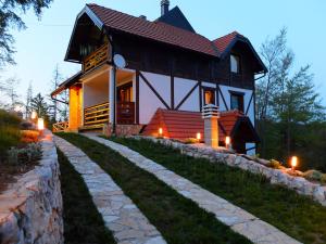 a large house with a stone path in front of it at Apartments Andrić in Kaludjerske Bare