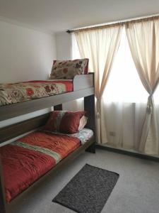a bedroom with two bunk beds and a window at Maravilloso Depto 3 habitaciones 1 baño - familiar Iquique in Iquique