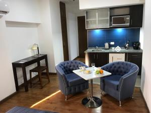 a kitchen with two chairs and a table in a room at Departamento BLUE in San Juan