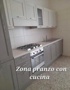 a kitchen with white cabinets and a stove top oven at Lo Studio del Pittore in Vasto