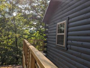 尤里卡斯普林斯Cabin #6 with hot tub deck and sunset view at Loblolly Pines的房屋一侧的甲板,带窗户