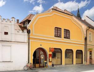 ein gelbes Gebäude an der Straßenseite in der Unterkunft Penzion Pohádka in Třeboň