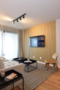 uma sala de estar com um sofá e uma televisão na parede em Vistas al Mar en Exclusivo Apartamento con Garage em Montevidéu
