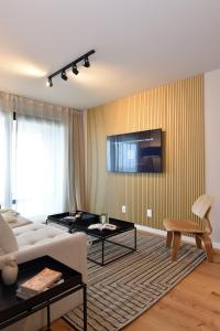 a living room with a couch and a tv on a wall at ZENHAUS - Vistas al Mar en Exclusivo Apartamento con Garage in Montevideo
