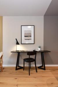 a black desk with a chair and a lamp at ZENHAUS - Vistas al Mar en Exclusivo Apartamento con Garage in Montevideo