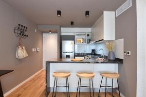 uma cozinha com um balcão e dois bancos em Vistas al Mar en Exclusivo Apartamento con Garage em Montevidéu