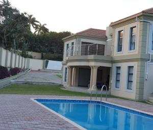 una casa grande con piscina frente a ella en Charis on Beaumont Home, en Ramsgate