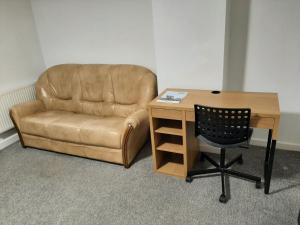 a brown leather chair next to a desk and a chair sidx sidx sidx at Exclusive Self-contained flat in Middlesbrough in Middlesbrough