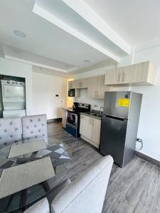 a kitchen with a stainless steel refrigerator and a table at Great Apartment with Private Terrace near Centro Cívico in Tegucigalpa