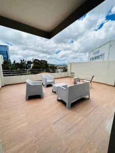 uma varanda com cadeiras e mesas num edifício em Great Apartment with Private Terrace near Centro Cívico em Tegucigalpa