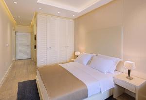 a bedroom with a large bed and a table and lamp at Aparthotel Villa Aria in Budva