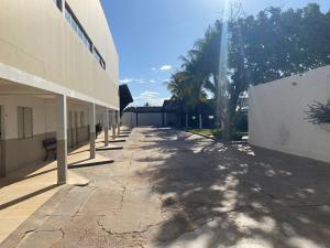 an empty sidewalk next to a building with a palm tree at Porto Center Hotel in Luís Eduardo Magalhães