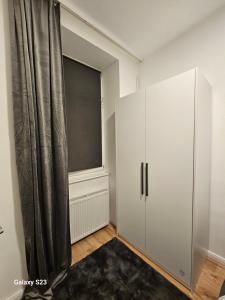 1 dormitorio con armario blanco y ventana en Comfort zone-10 min from the Center, en Viena