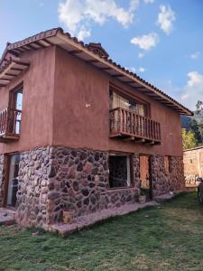 una casa de piedra con un balcón en un lateral. en La casita del valle, en Cusco