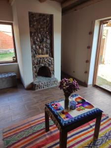 sala de estar con mesa y chimenea en La casita del valle, en Cusco