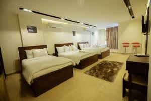 1 dormitorio con 2 camas y 2 sillas rojas en King Khafren View INN en El Cairo