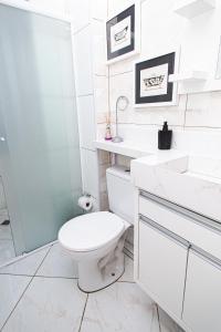 ein weißes Bad mit einem WC und einem Waschbecken in der Unterkunft Amplo e iluminado apto central para temporada in Balneário Camboriú