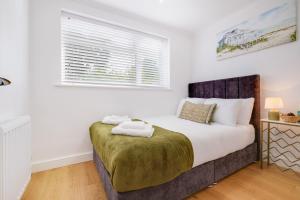 Un dormitorio con una cama grande y una ventana en Luxury 5 BDR 2 BA House with Parking in Sandhurst By 360Stays, en Sandhurst