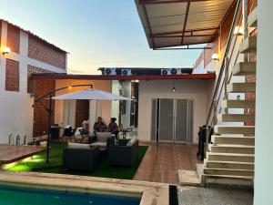 a patio with a table and an umbrella next to a pool at La casita de Vale in Tarapoto +12 photos
